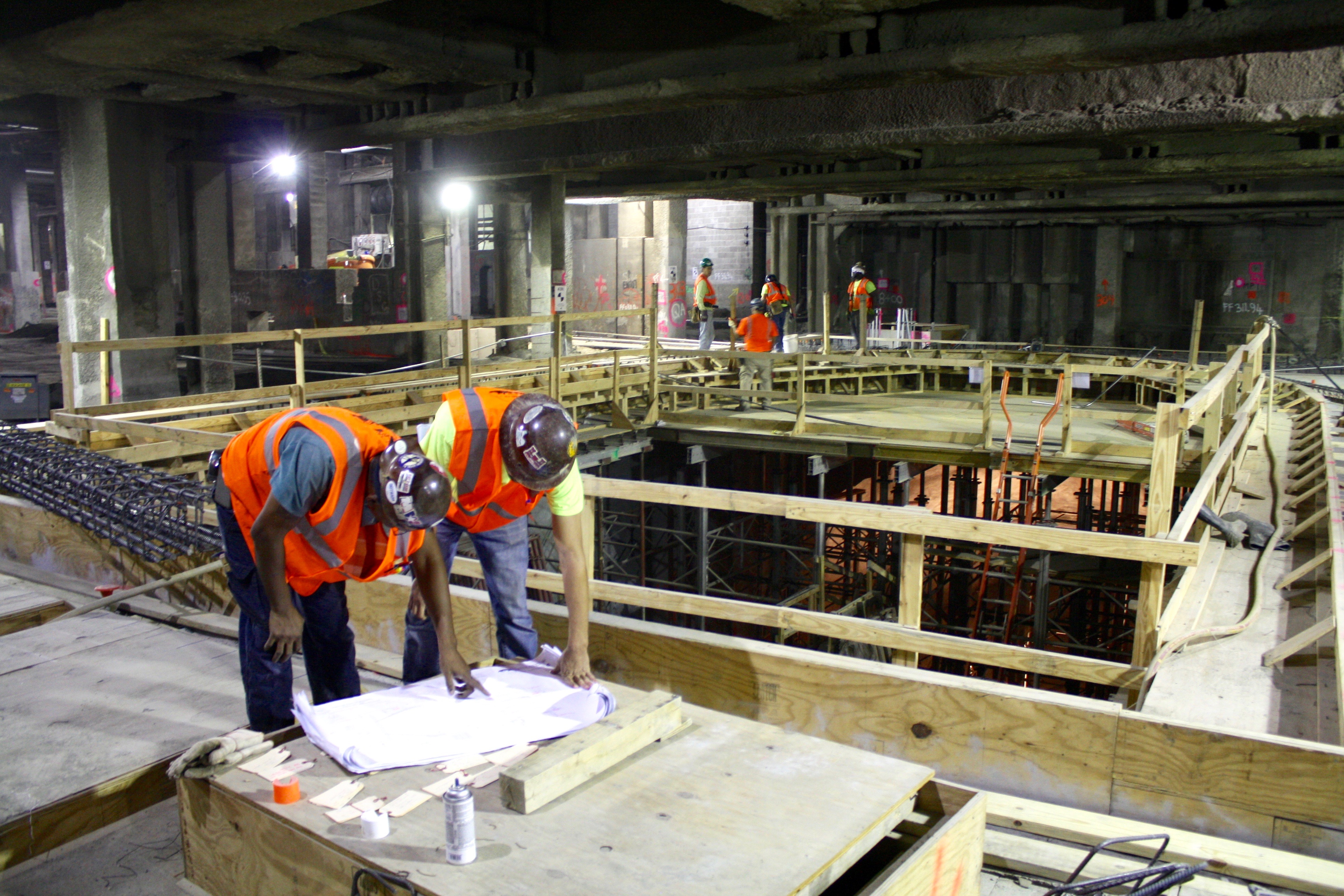 In “Caves” Below Grand Central, East Side Access Project on Track 7 Workers studying construction plans at the concourse level of the new LIRR terminal, which is scheduled to open by December 2022. | YANNIC RACK