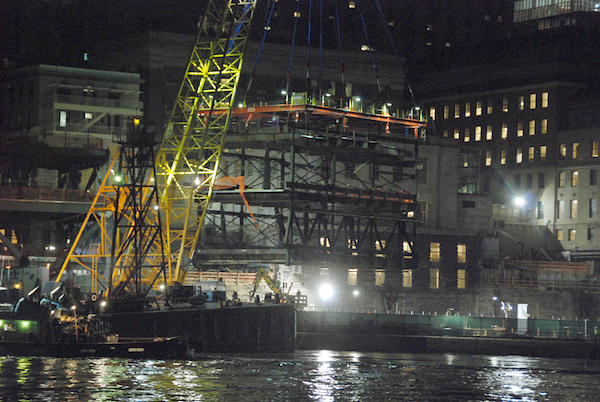Rockefeller University’s Two-Acre Expansion Sails Up the East River 6 A close-up of the module being put in place, with the FDR Drive at the level where there is green fencing. | FRANK FARANCE