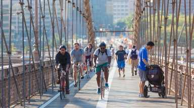 People cycling and walking on Brooklyn Bridge