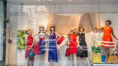 Shoppers pass by the storefront of boutique Designer Promise in Manhattan