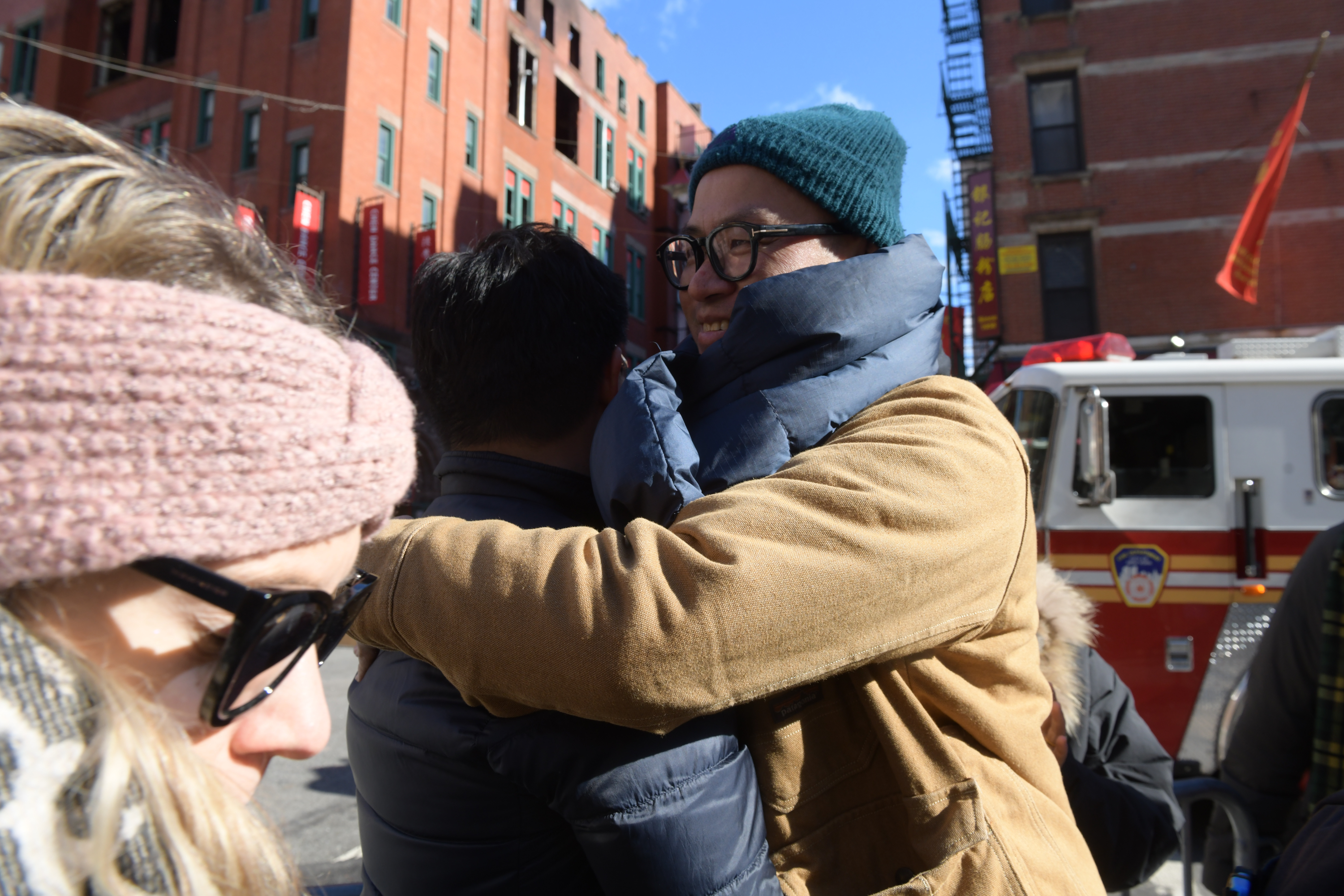 Friends embrace after seeing damage to a beloved building and destination. 
