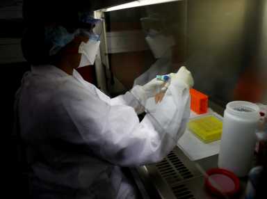 A laboratory technician works with samples during a coronavirus analysis simulation at the Malbran institute in Buenos Aires