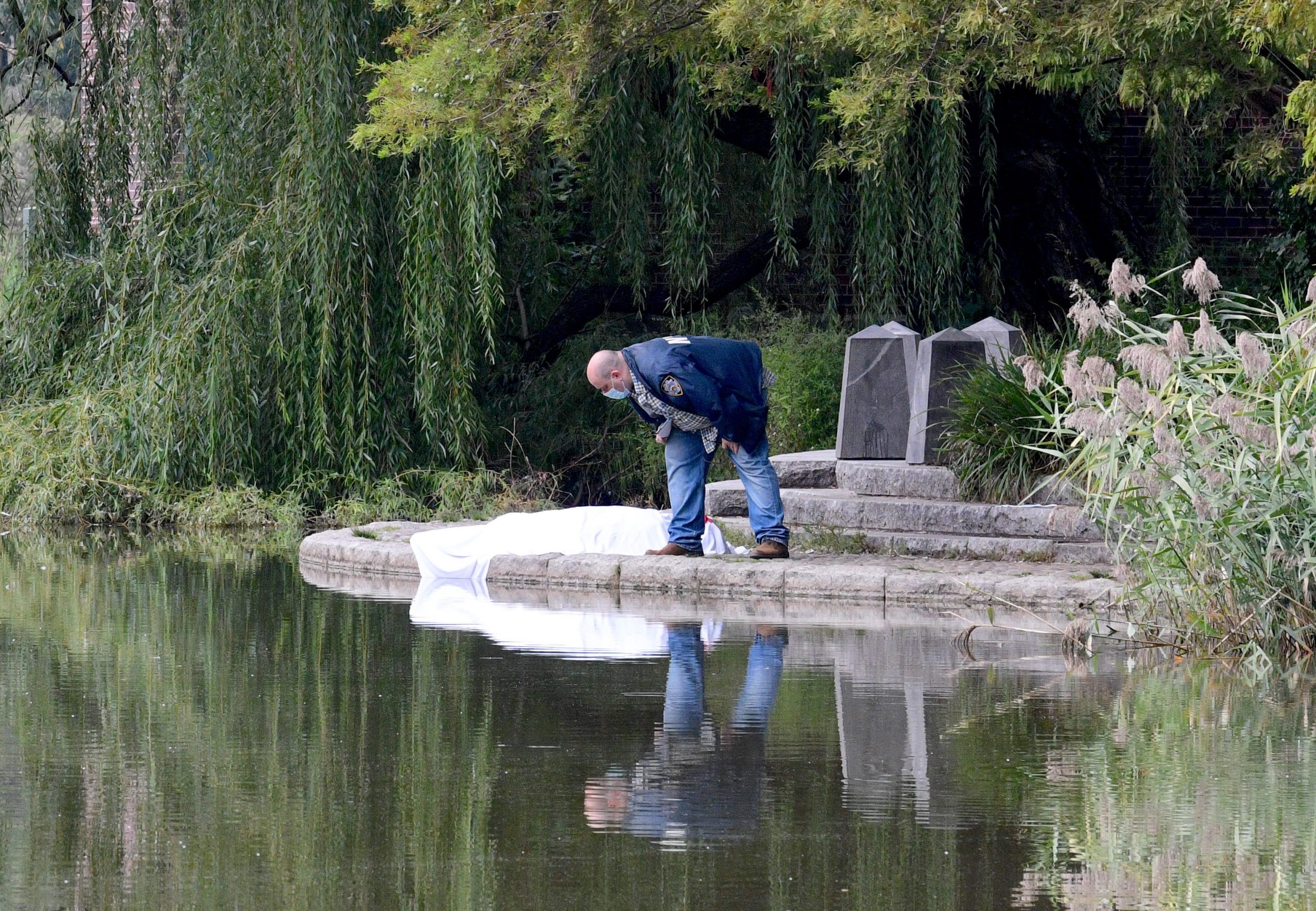 A white, blood-stained sheet covers the body of a man pulled from the Harlem Meer in Central Park