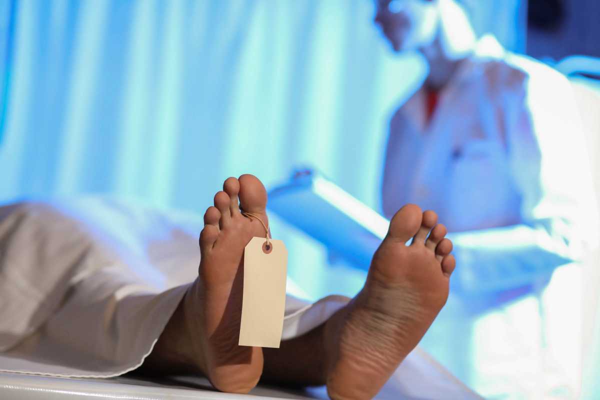 Medical Examiner with corpse in morgue.