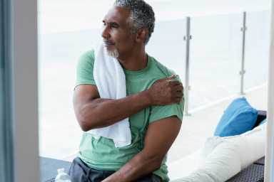 Mature man stretching after at home workout