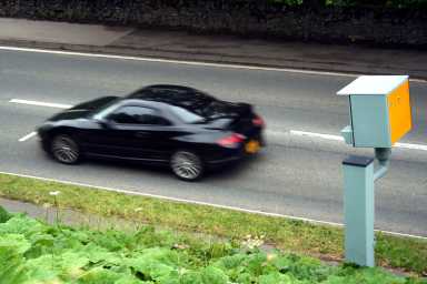 Car going past a speed camera on a street