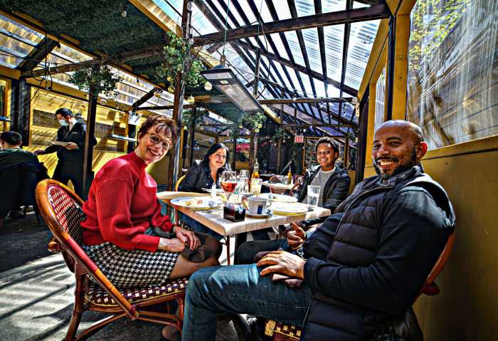 Patrons eat at an outdoor dining shed in New York.
