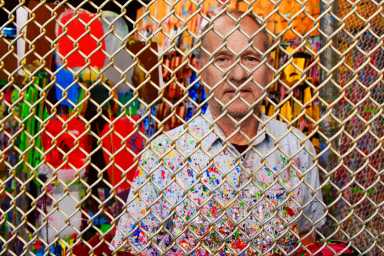 Steve Keene in his cage, a structure inspired by a Frank Gehry show