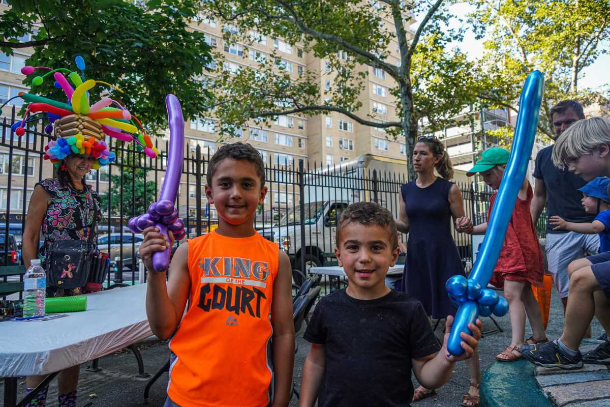 Children received balloon swords during the 13th Precinct's National Night Out Against Crime event