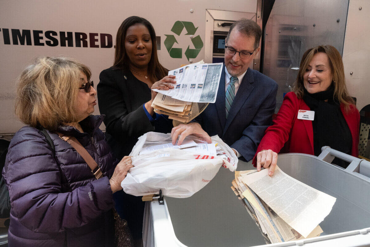 NY AG Letitia James, Manhattan Borough President Mark Levine, Beth Finkel help a woman get her documents ready for shredding