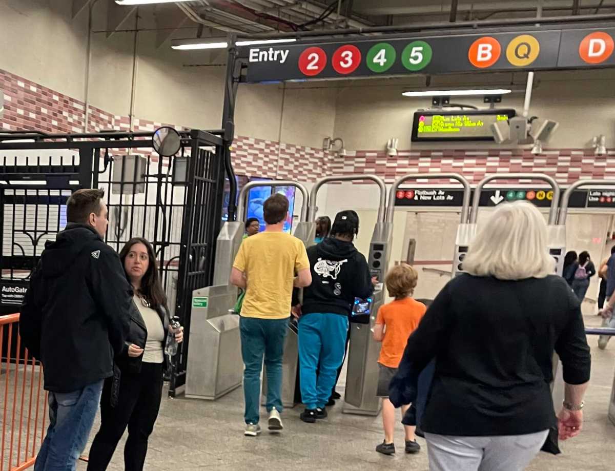 People paying fare at a turnstile in Brooklyn