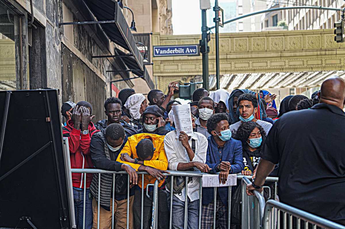 Migrants wait outside the Roosevelt Hotel in Manhattan.
