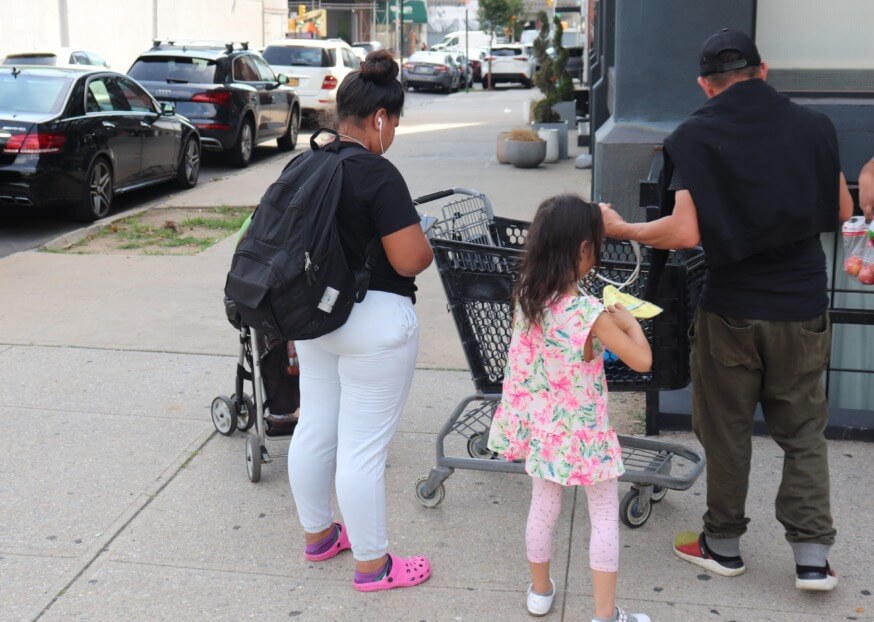 A family outside The Paper Factory hotel in Long Island City that has been converted into a shelter for migrants