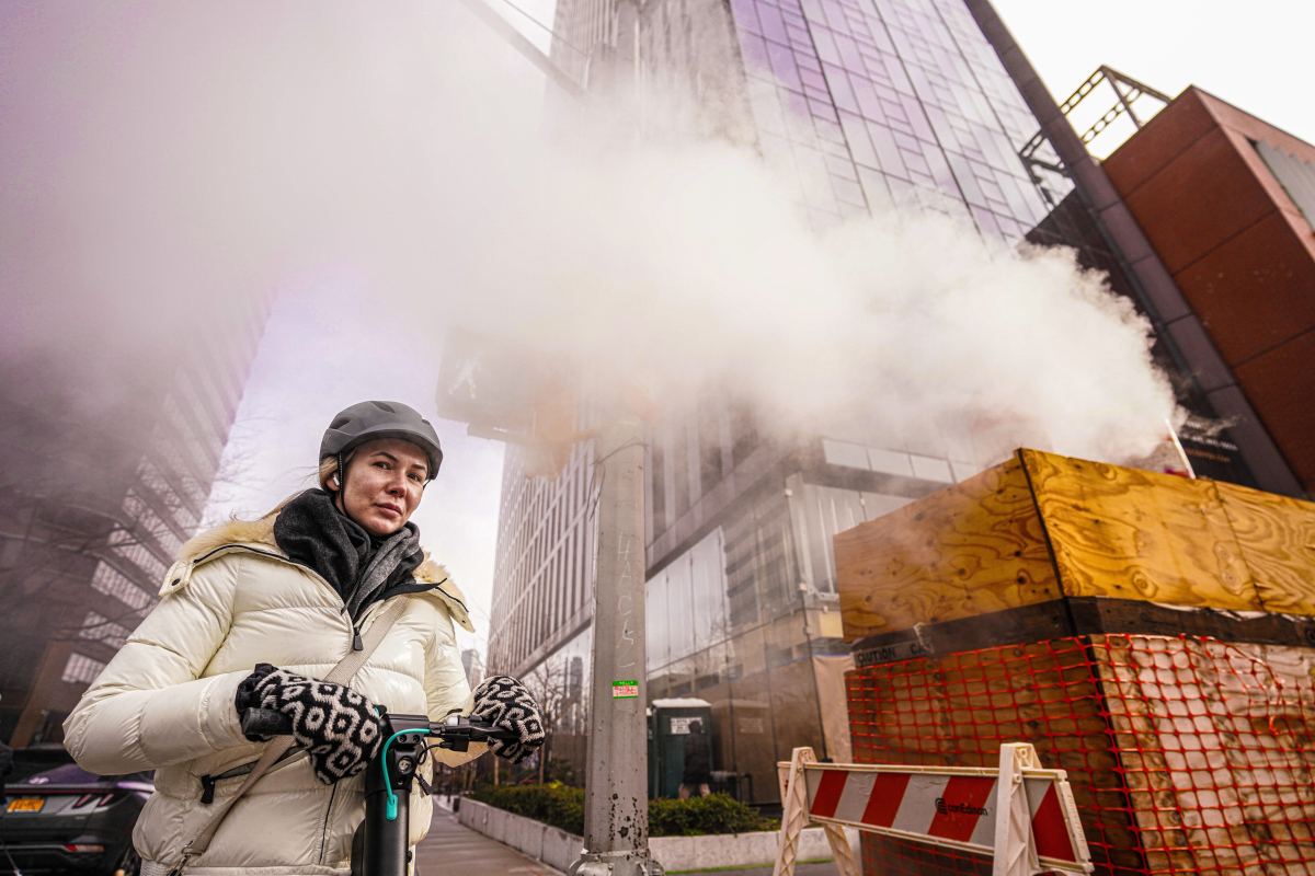A New Yorker walks past a smokestack during a rainy, not snowy, day in Manhattan