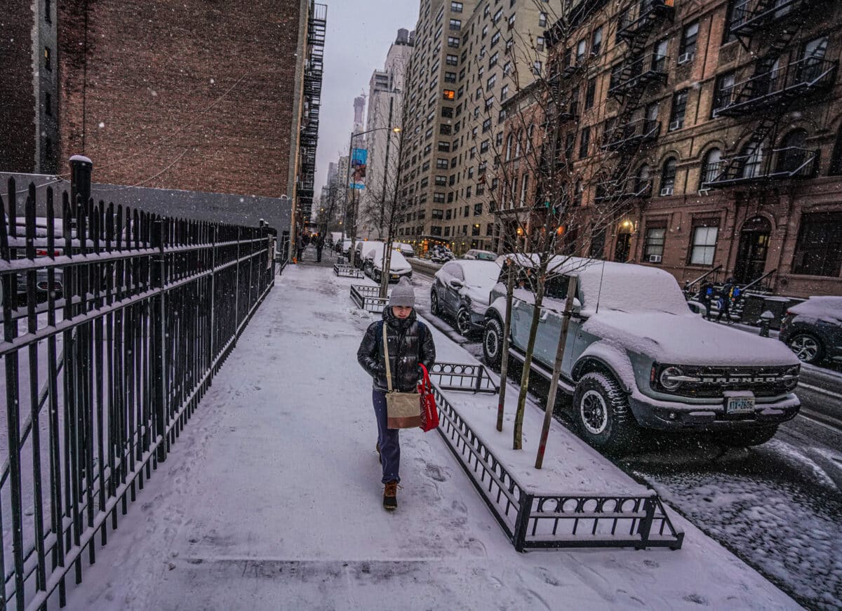 SNOWLESS STREAK OVER! NYC finally sees a legitimate snowfall after 701 days 14 A New Yorker walks on snowy streets