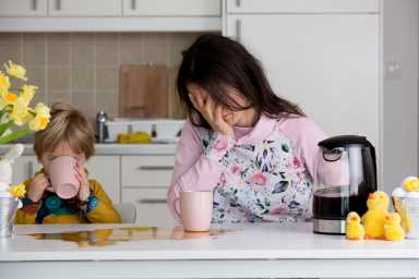 tired woman at table with child in how to get more deep sleep post