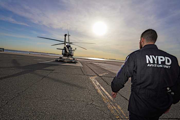 A soaring call of duty: How NYPD Aviation Unit members do it all to fly high and save lives 2 Police officer approaching an NYPD helicopter