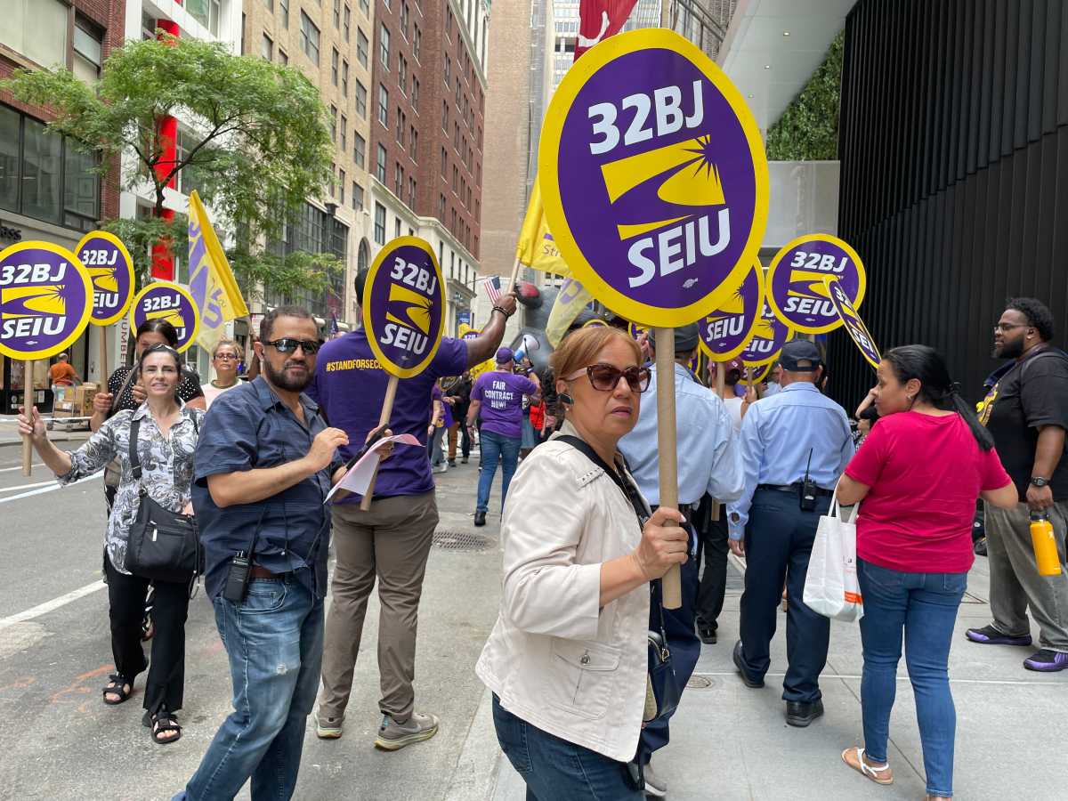 Midtown building cleaners go on strike to protest wage cuts and other 'drastic' changes 1 32BJ union members holding signs and in the daytime rally in Midtown to protest wage cuts