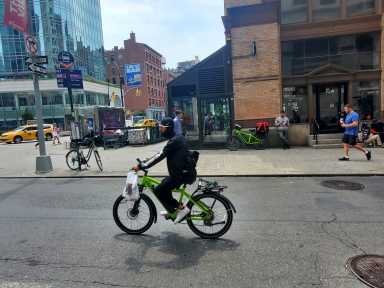 Editorial | NYC tries to go both ways on e-bike and car traffic in parks 14 E-bike with operator riding along a NYC street with buildings