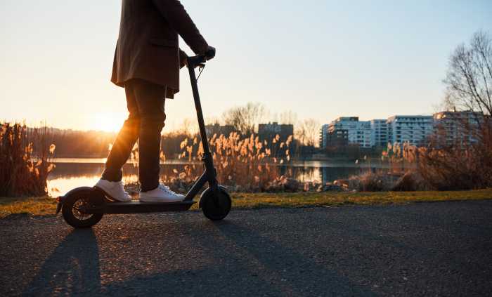Op-Ed | Like the Bronx, Queens will come to love e-scooters 5 Unrecognisable man riding electric scooter in city during sunset
