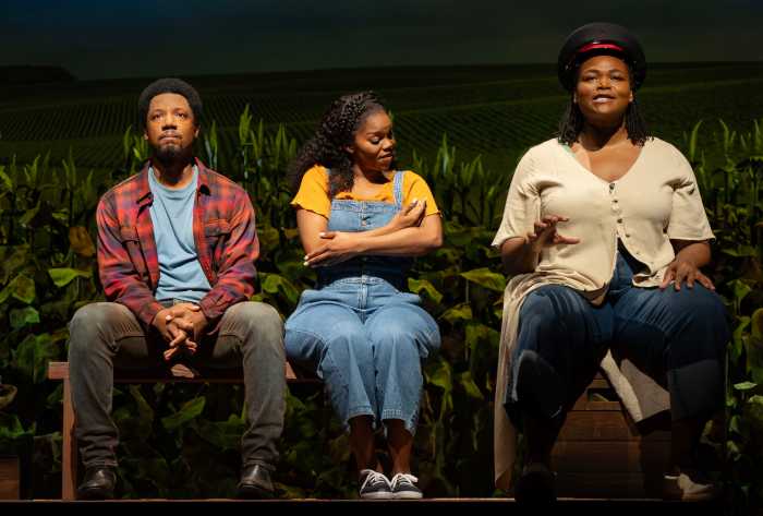 2 woman and 1 men sitting at chairs