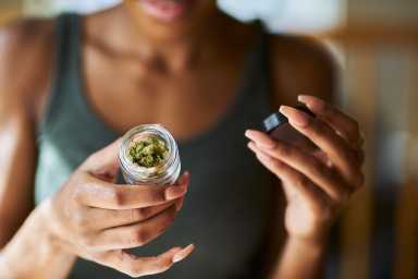 Shopping local and legal: Most NY marijuana users buying their buds from licensed operators, state report finds 32 Woman holding container of cannabis