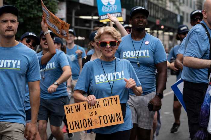 2024 Labor Day Parade will celebrate the city's workers: The backbone of the Big Apple 7 people in blue shirts participating in Labor Day Parade with a sign that says NYC is a Union Town