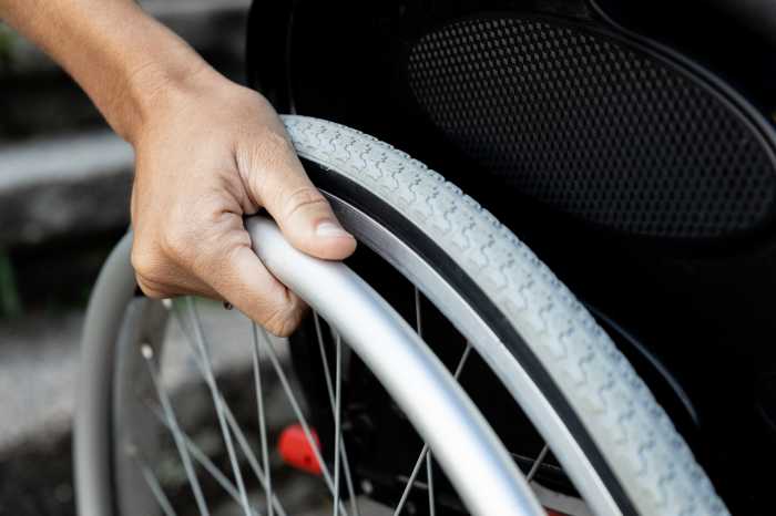 Op-Ed | Time to do right for New Yorkers with disabilities 2 Close-up of a woman's hand on the wheel of a wheelchair. Concept of reduced mobility