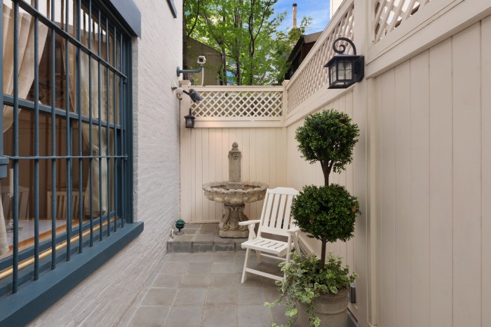 PHOTOS: Real estate magnate's $15 million home on Manhattan's Upper East Side hits the market 4 an outdoor area with a chair and tree next to a home