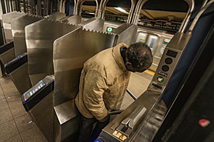 person going through a turnstile in a NYC subway