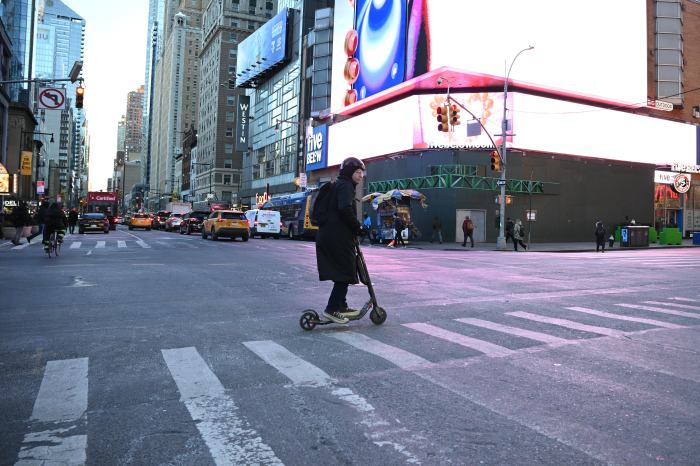 Congestion pricing: Cabbies and commuters continue to fume over Manhattan toll era 3 person using a scooting in Manhattan crosswalk