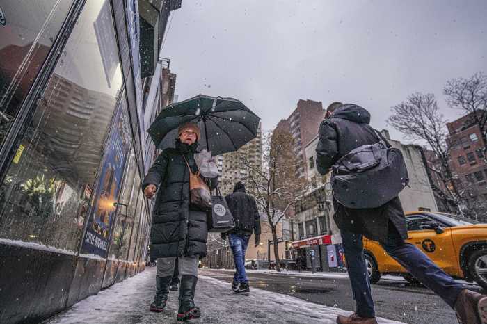 Snowstorm in the forecast Sunday as NYC ahead of an arctic blast 2 A women in snow fall holding umbrella