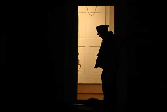 Stray bullet hits, wounds Bronx woman as she sleeps in her home: cops 3 Silhouette of police officer standing in doorway of crime scene