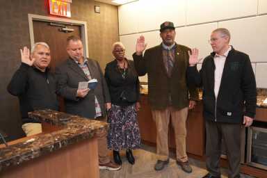 a group of people standing in a room, part of TWU Local 100