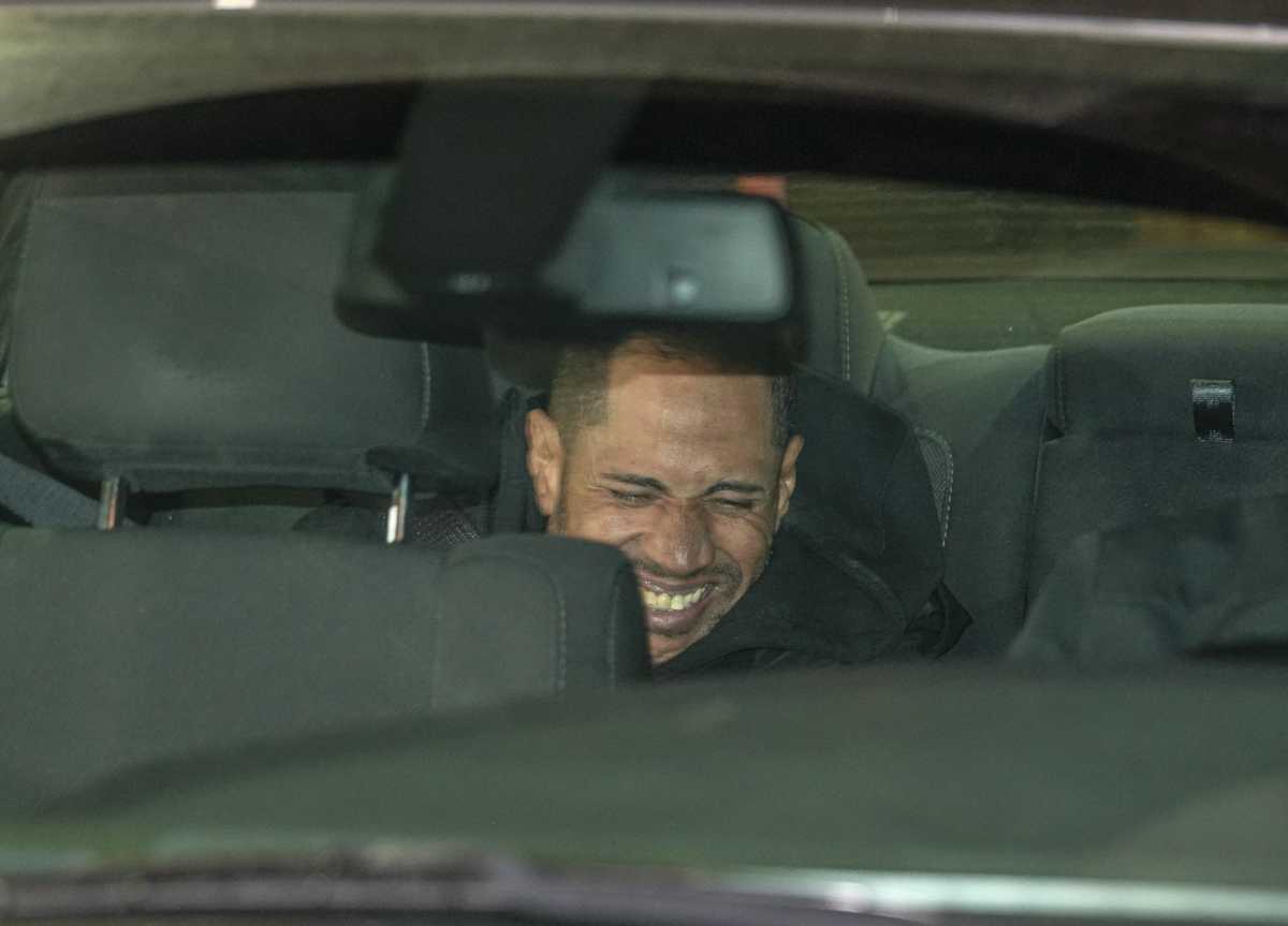Bronx murder suspect smiling in back of police car.