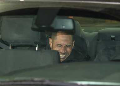 Bronx murder suspect smiling in back of police car.