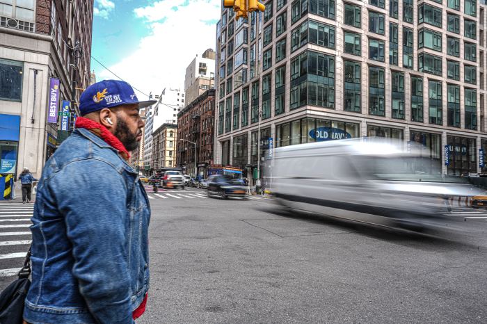 man crossing a busy street in NYC