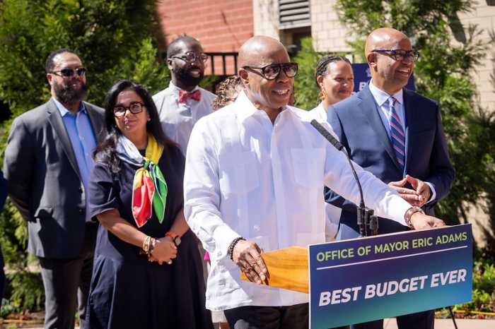 Mayor Adams wearing sunglasses while speaking about housing investments