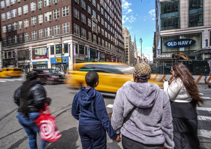family crossing a busy NYC street