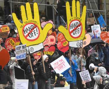 'Hands Off' march in Manhattan sees tens of thousands protest Trump/Musk agenda and demand end to turmoil 4 Protesters hold Hands Off signs in march against Trump in Manhattan
