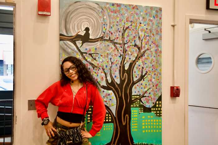 Jasmine Alford, alumni artist at Artistic Noise, poses in front of her painting at Midtown courthouse