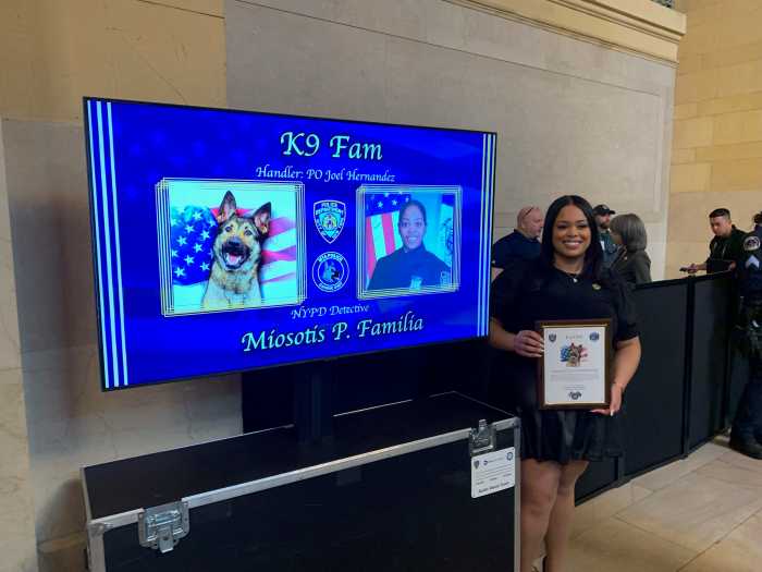 woman next to a screen with a photo of slain NYPD officer Miosotis Familia 