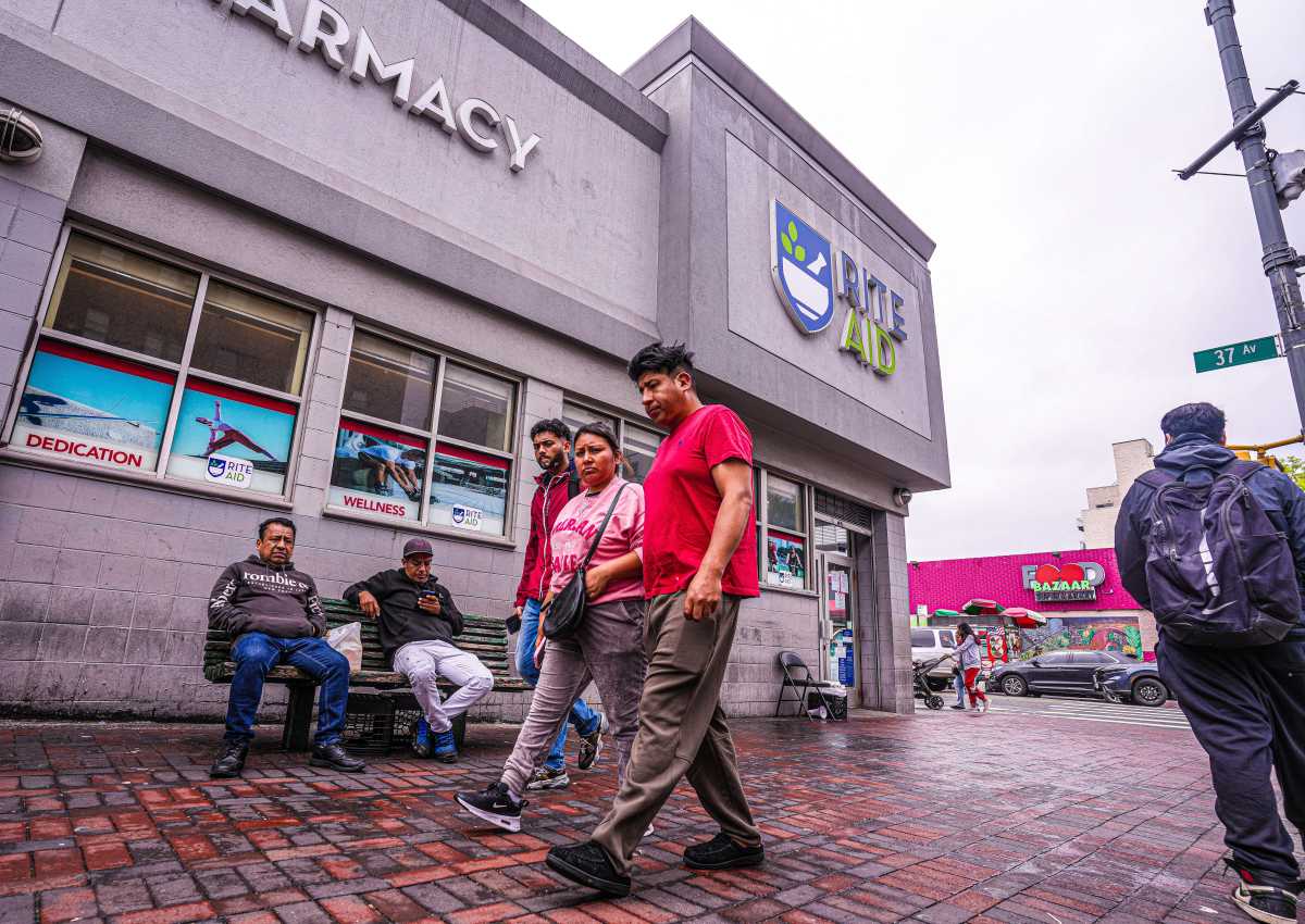 People walking in front of Rite Aid's Junction boulevard location in Queens