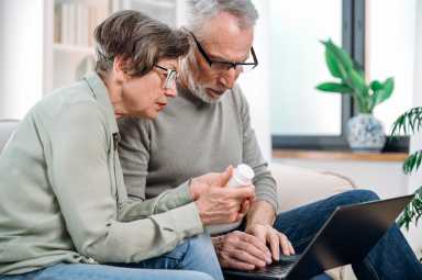 elderly couple using laptop, searching medication on pharmacy website to make online order. mature man and woman have medical consultation with doctor by chat on notebook.