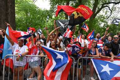 Bongo drum beats and the celebratory blare of trumpets reverberated throughout the cluster of storefronts and office buildings during Sunday's National Puerto Rican Day Parade in Midtown. 