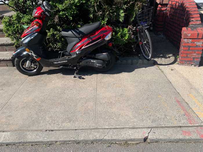 a red and black moped, one of many unregistered mopeds in NYC
