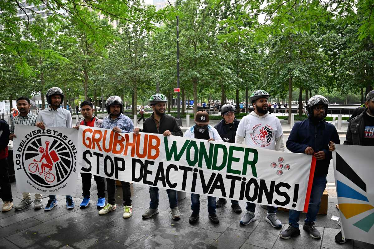 Delivery workers holding a sign that reads Grubhub wonder stop deactivations