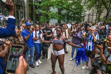 Woman walking in baby oil shower outside courthouse