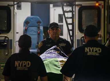 Police carry flag-draped body on gurney of police officer killed in mass shooting