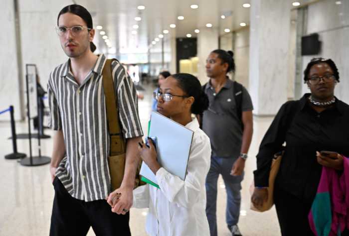 Love in the time of ICE raids: Newlyweds face immigration court judge in Lower Manhattan hoping to stay together 13 Man and woman holding form while walking inside immigration court